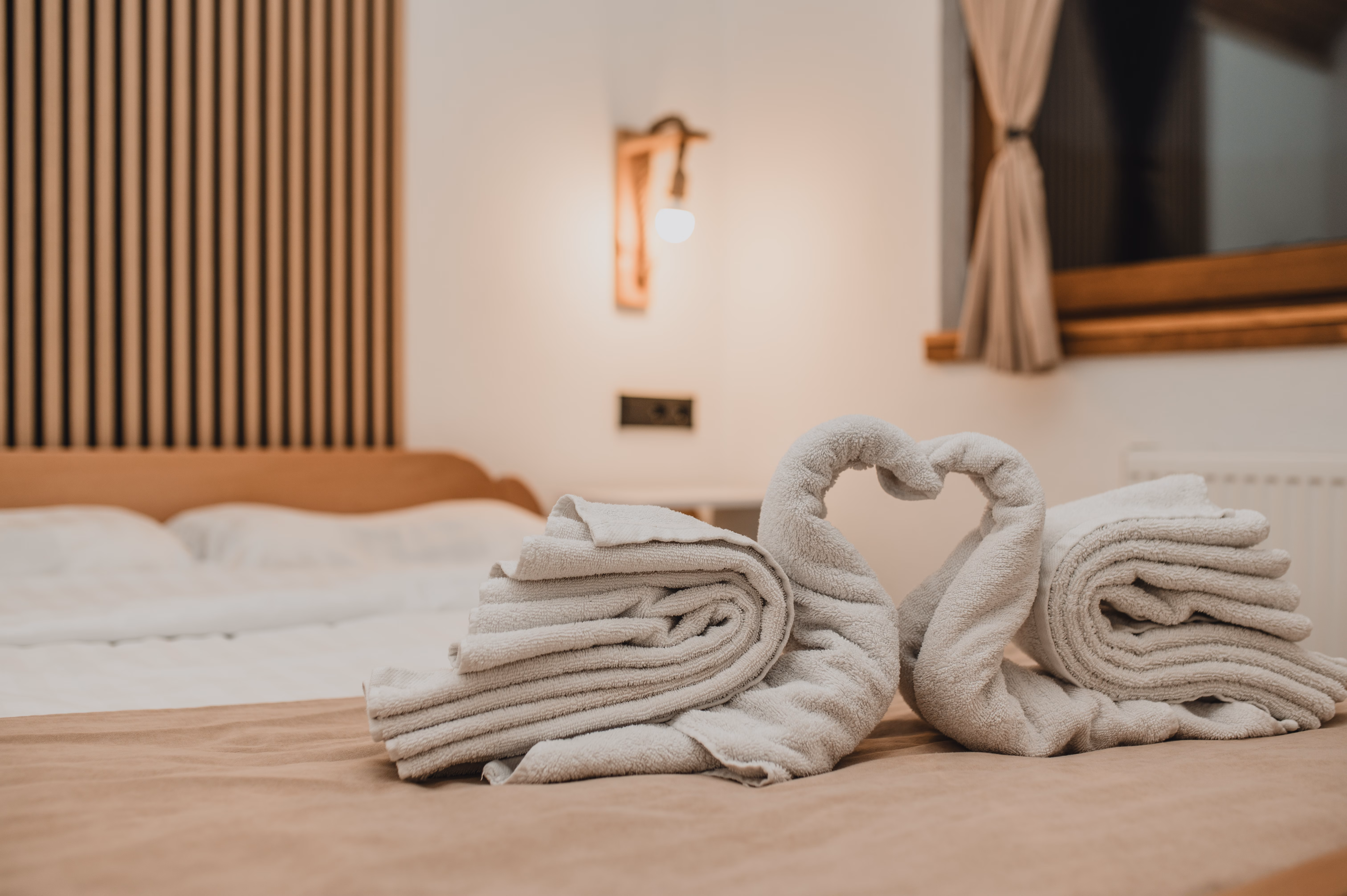 Romantičan aranžman ručnika u obliku srca u spavaćoj sobi