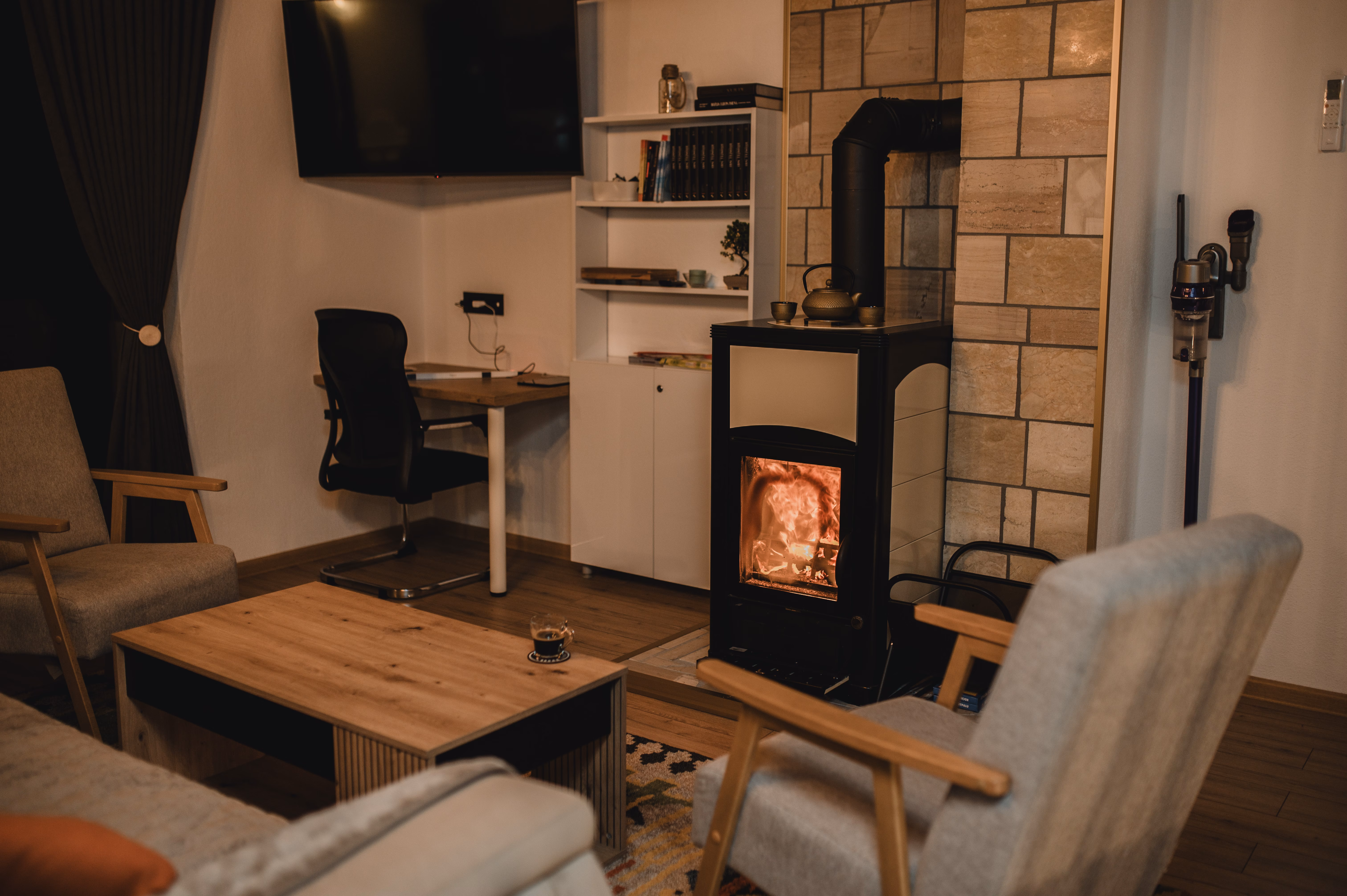 Dnevni boravak s kaminom na drva, radnim stolom i udobnim foteljama