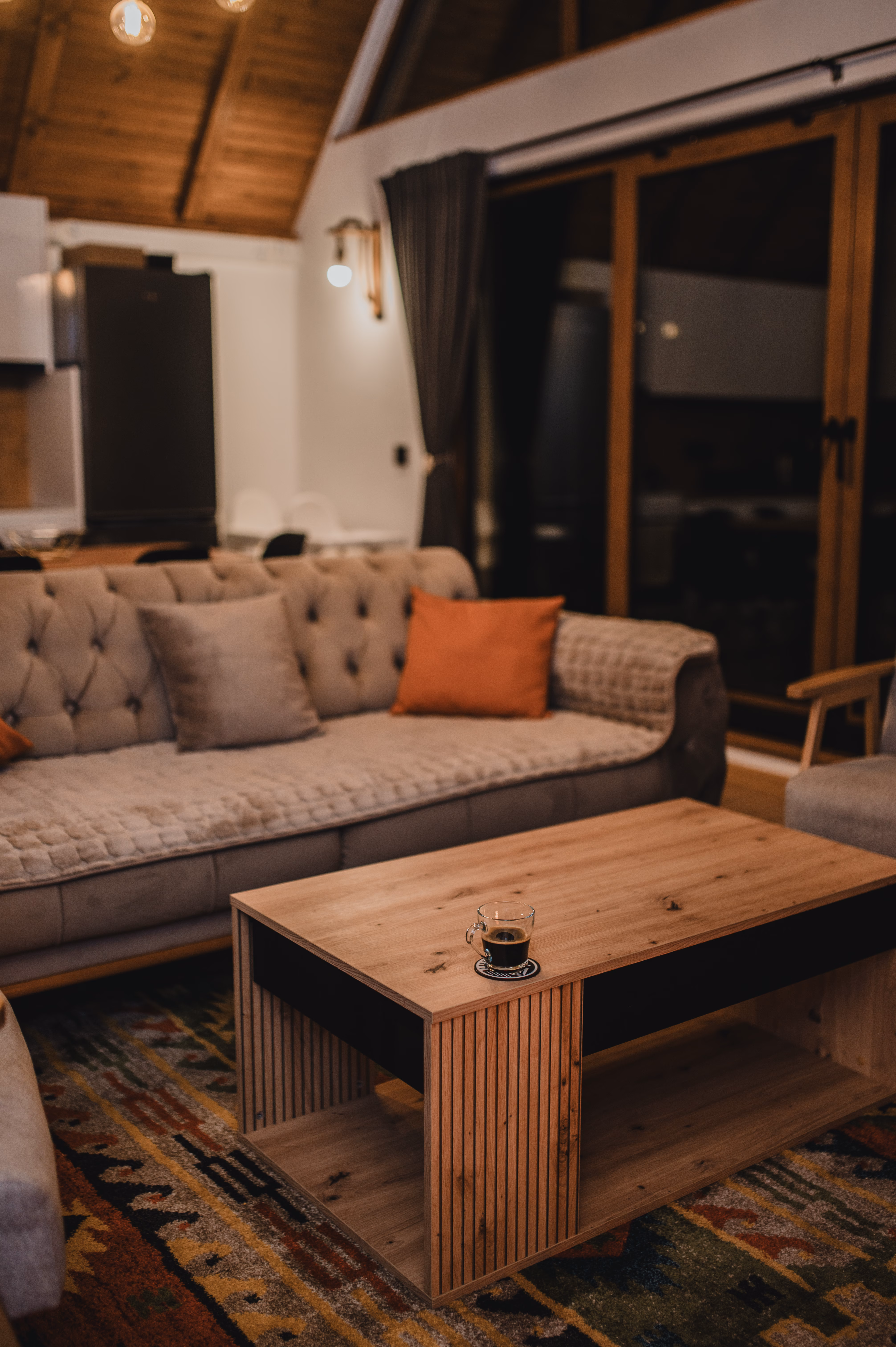 Udoban kauč s narandžastim jastucima i tradicionalnim kilim tepihom