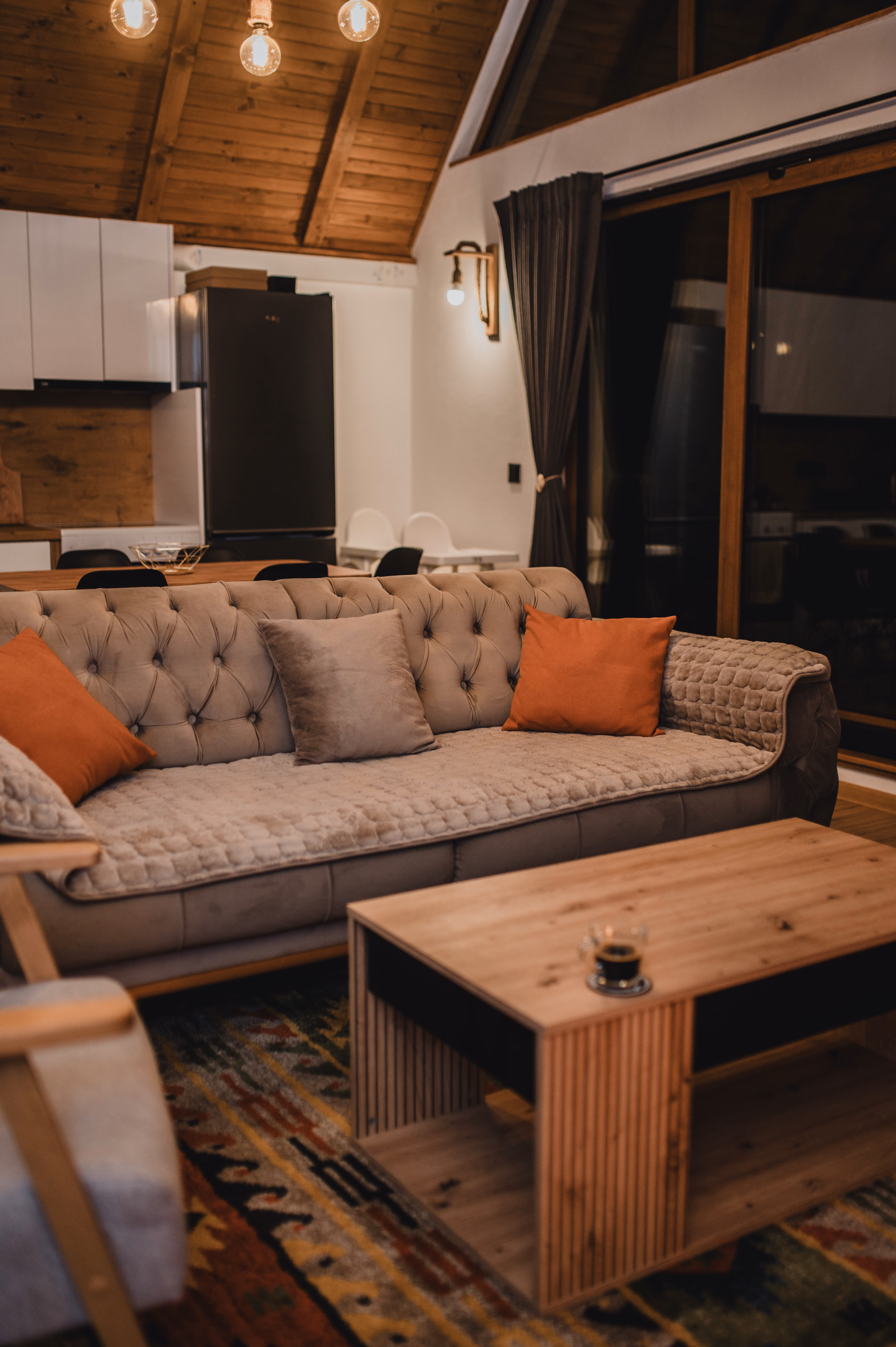 Otvoreni dnevni prostor s kuhinjom i A-frame drvenim stropom