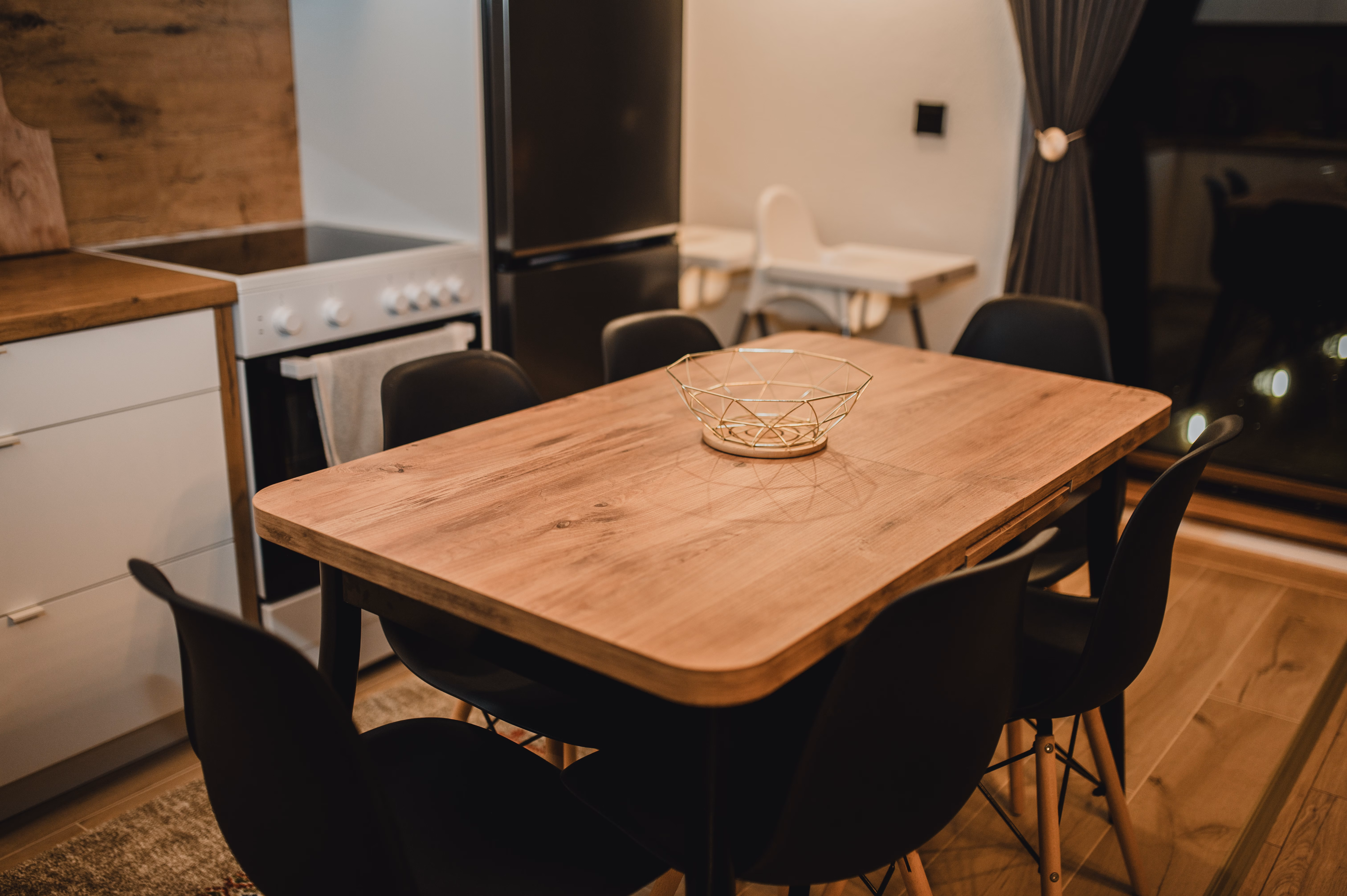 Blagovaonica s drvenim stolom i crnim Eames stolicama