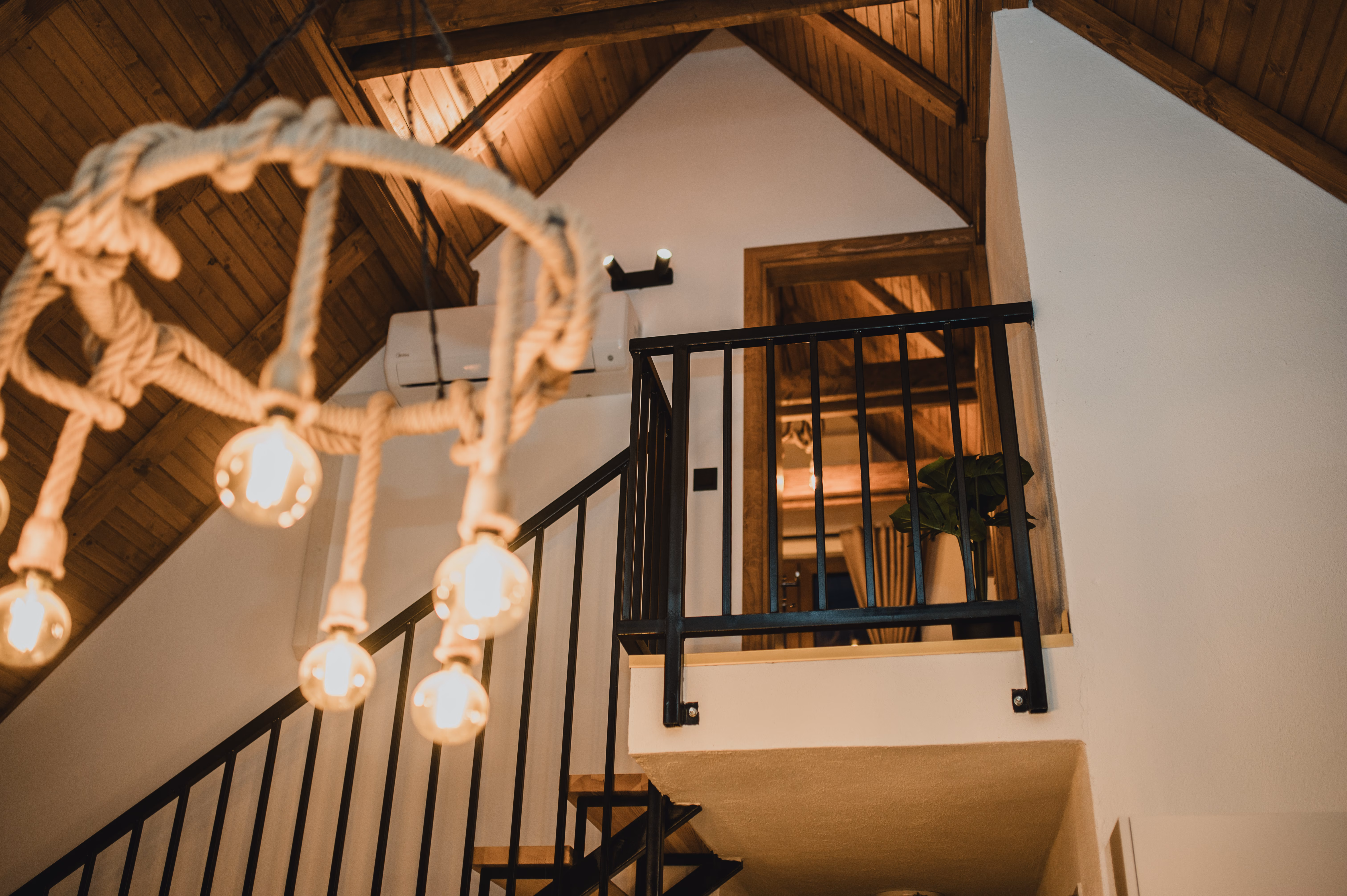 Otvoreno stepenište s crnom metalnom ogradom koje vodi na gornji sprat