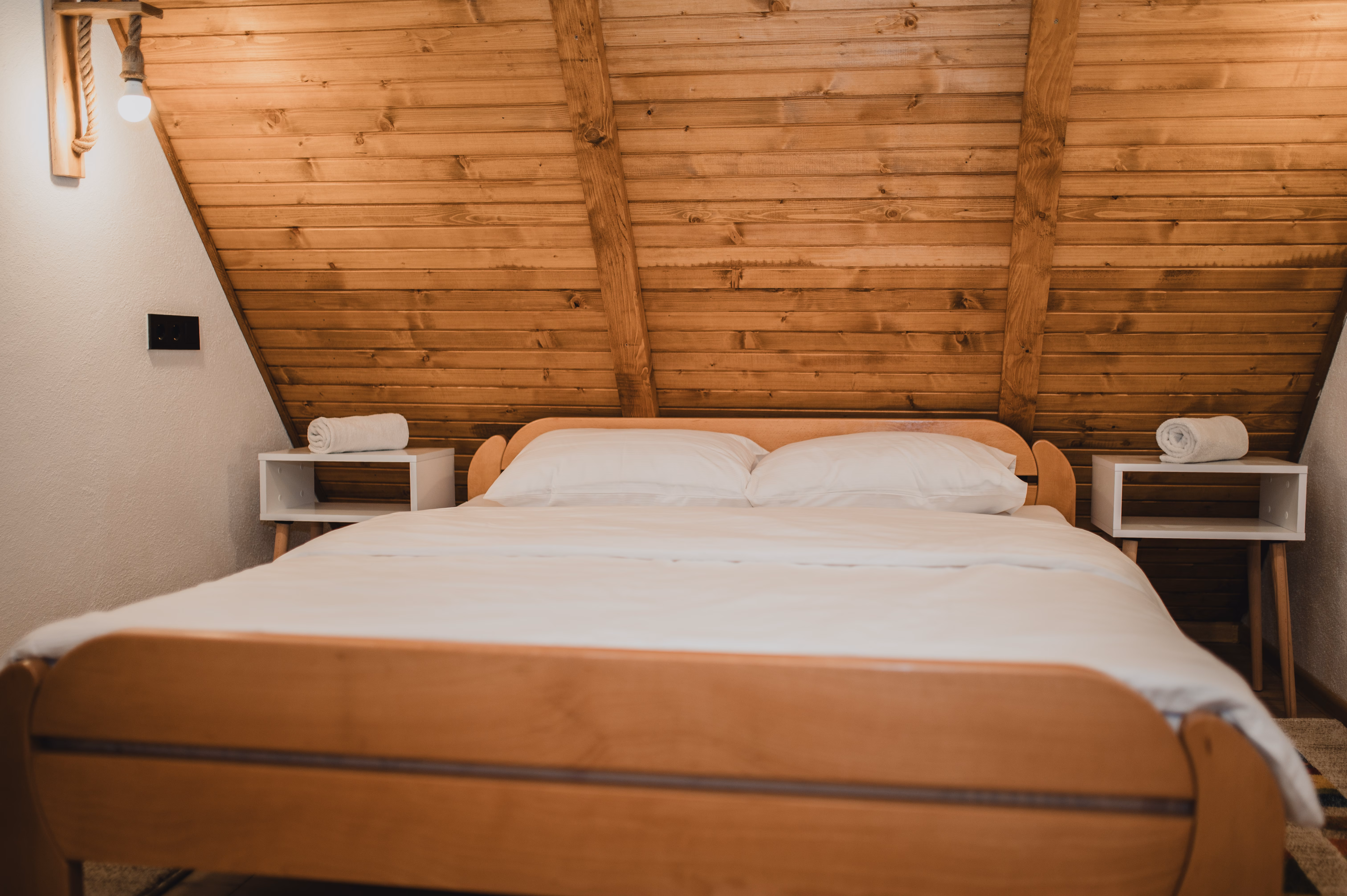 Potkrovna spavaća soba sa saonicama krevetom ispod A-frame drvenog stropa