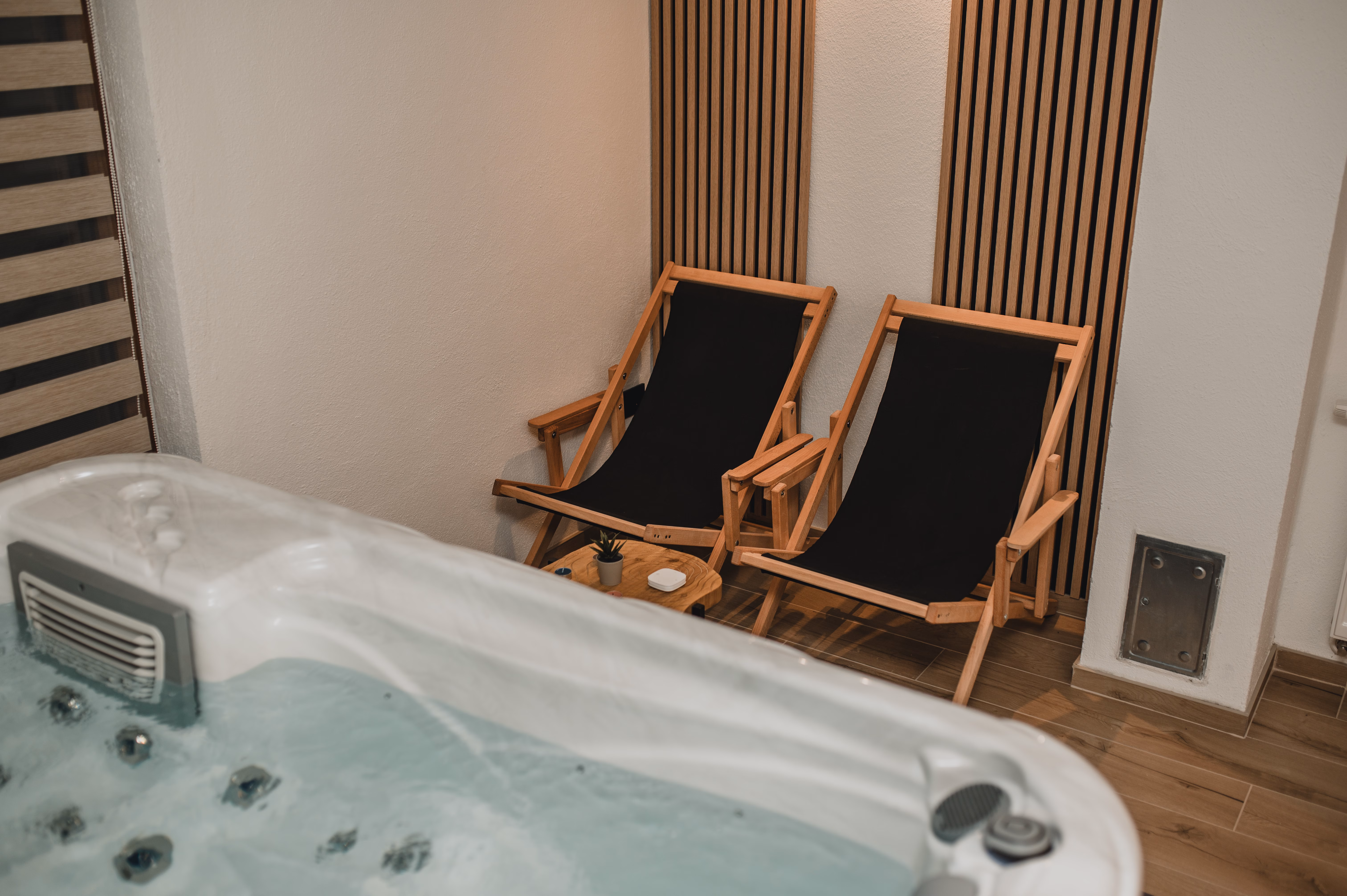 Spa prostor s jacuzzijem i drvenim ležaljkama za opuštanje