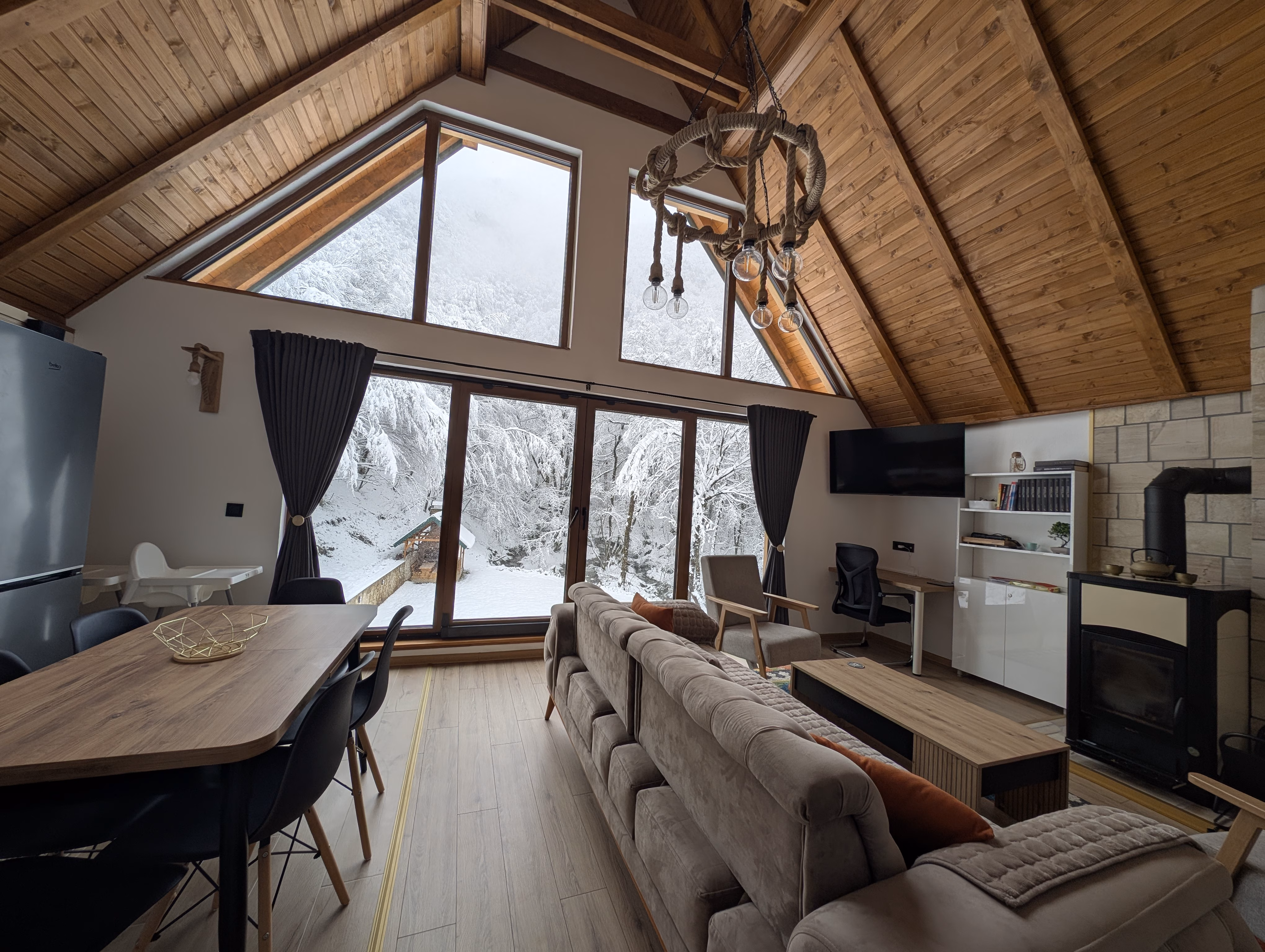 Zimska idila - dnevni boravak s pogledom na šumu prekrivenu snijegom